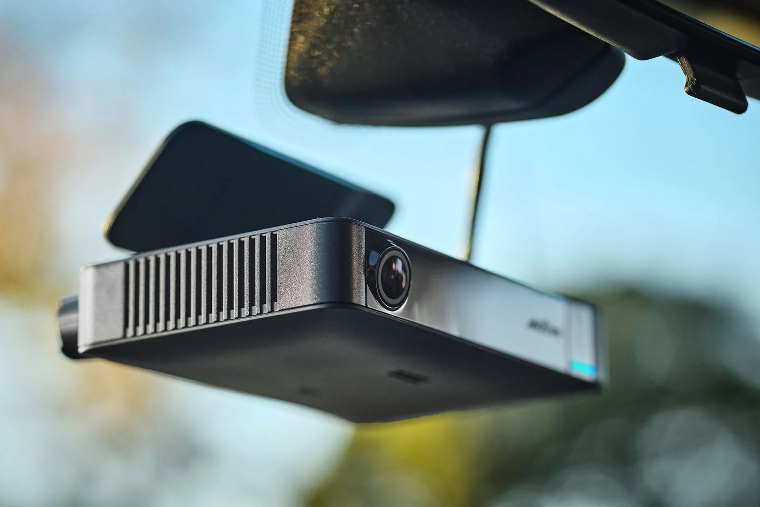 Motive AI Dashcam Plus mounted below a rearview mirror, angled view