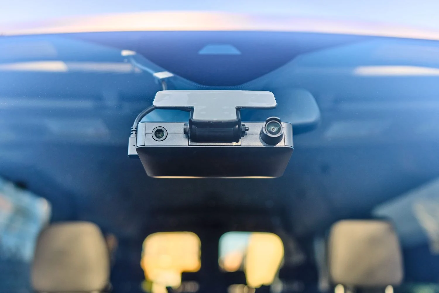 Motive AI Dashcam Plus on a windshield showing its road-facing and in-cab lenses